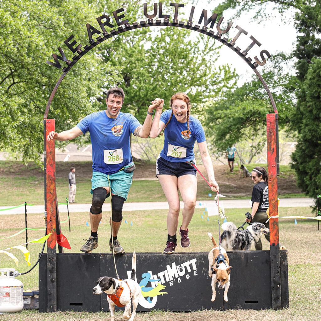 John and Taylor completing an obstacle race with dogs