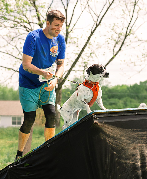 John and his dog completing an obstacle course together