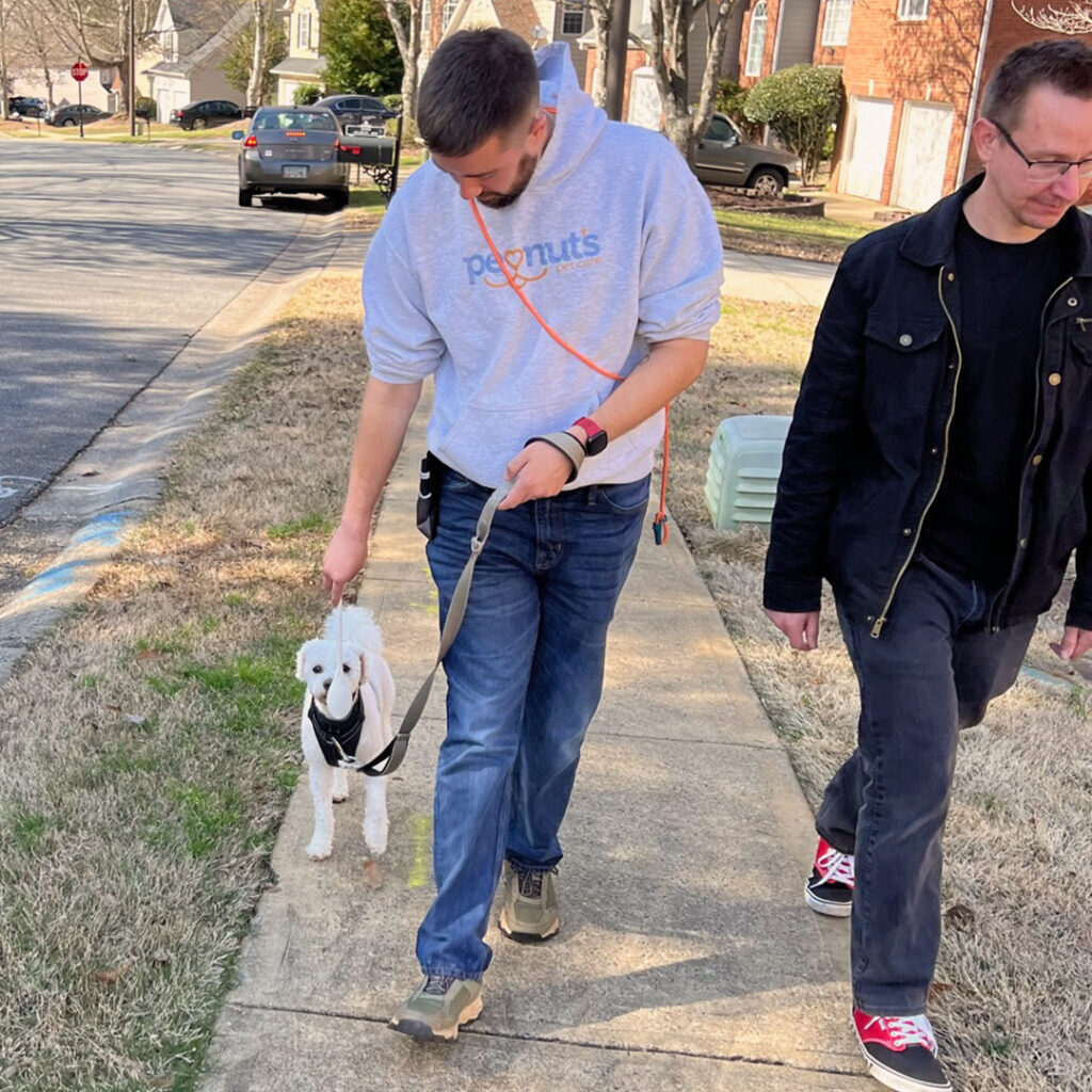 John working with a dog and owner on leash skills in a neighborhood