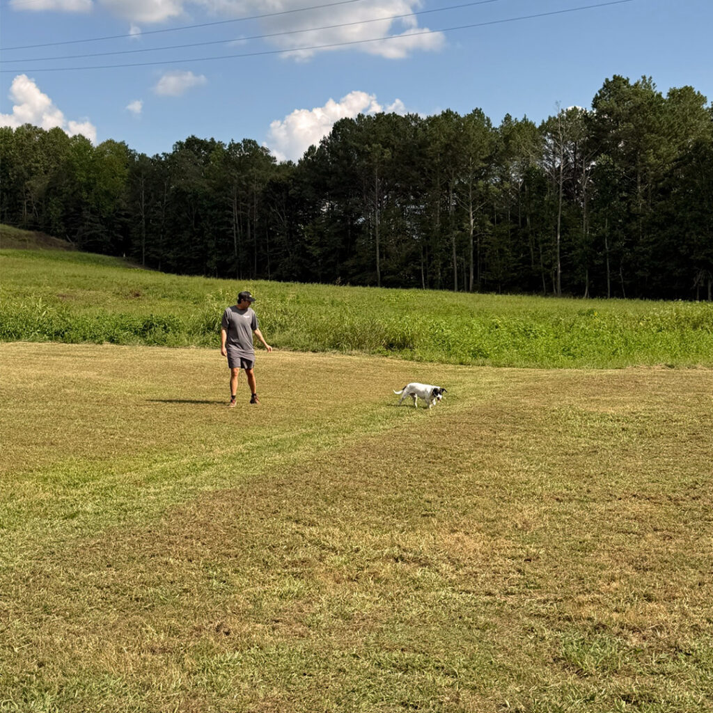 John working with a dog during an outdoor behavior training session