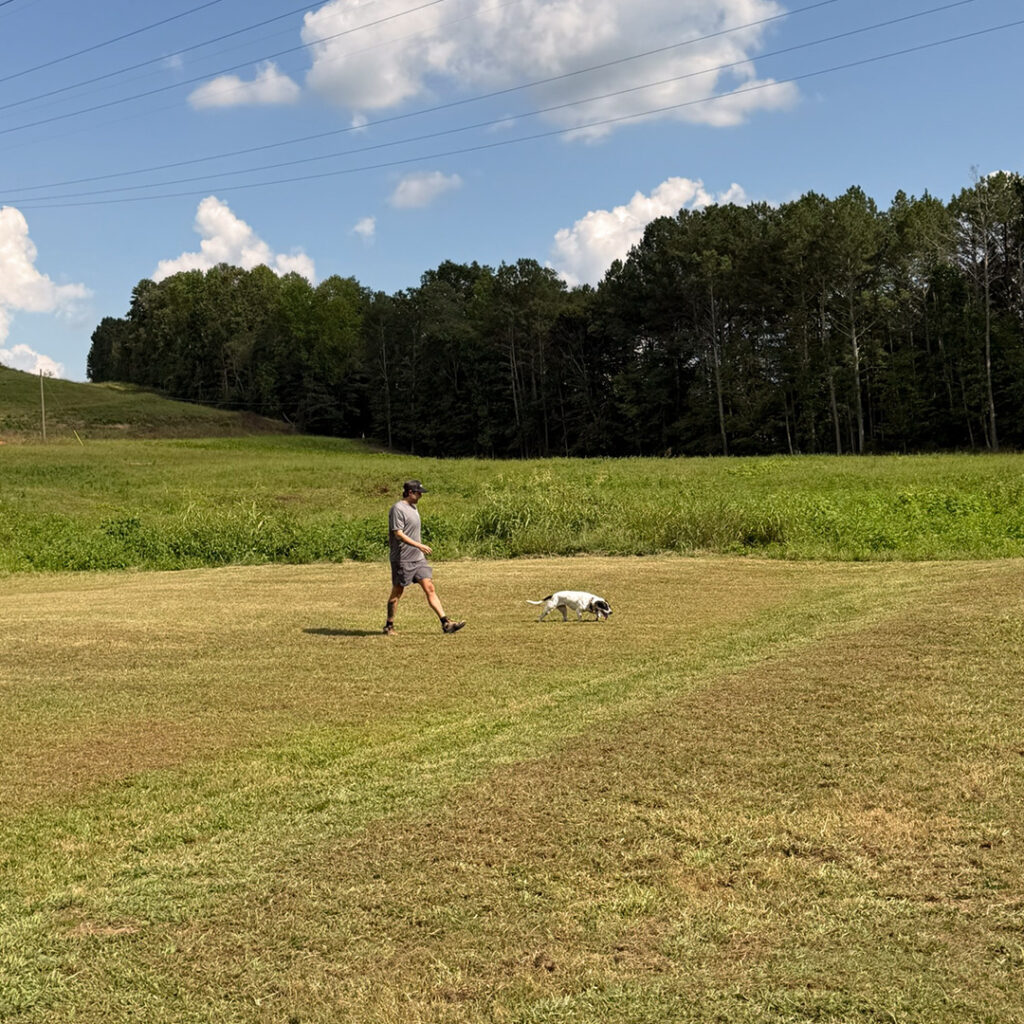 John working with a dog in the outdoor training field at Peanut's Pet Care